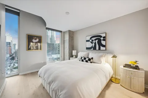 a bedroom with a bed and a large window