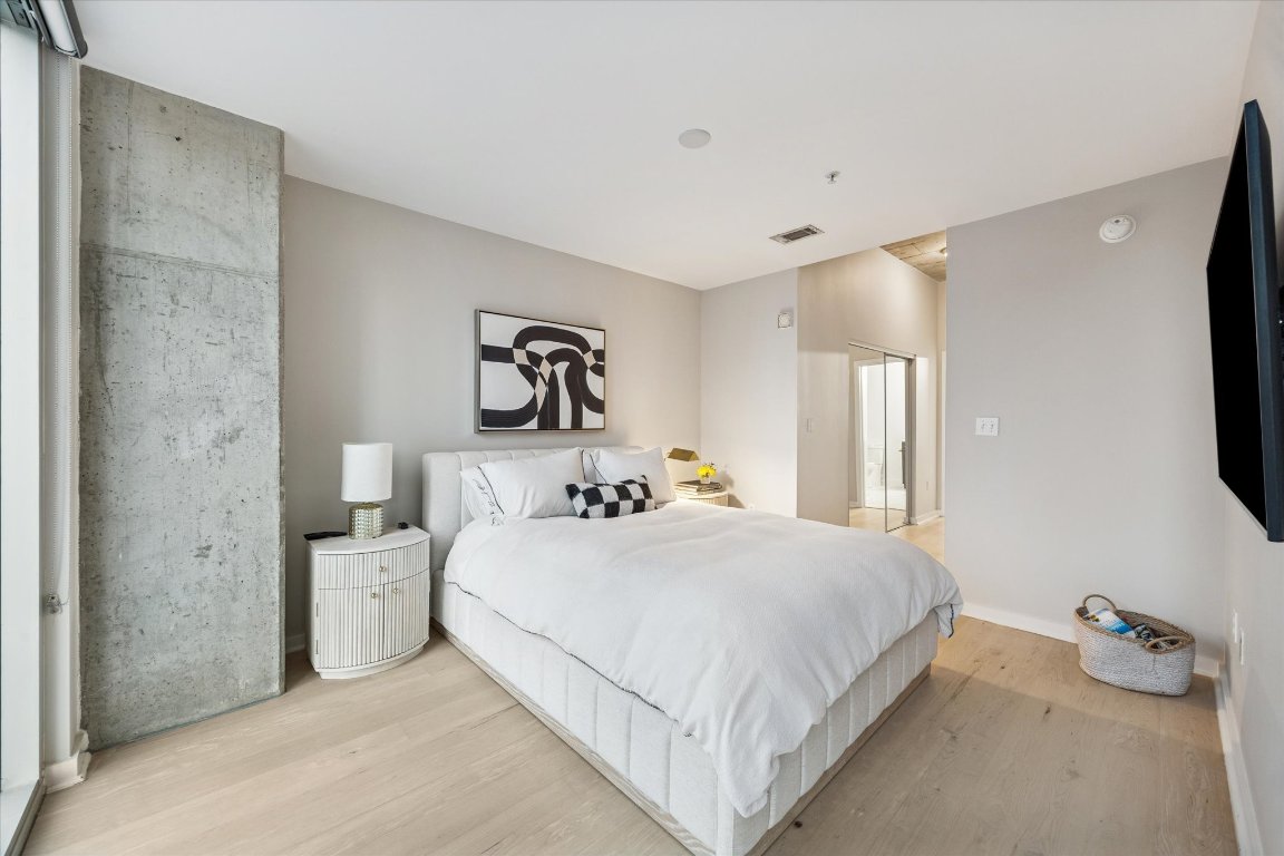 360 Nueces Street, Unit 1417 Austin, TX 78701 - Photo 19 of 40 a bedroom with a bed and a flat tv screen on the wall