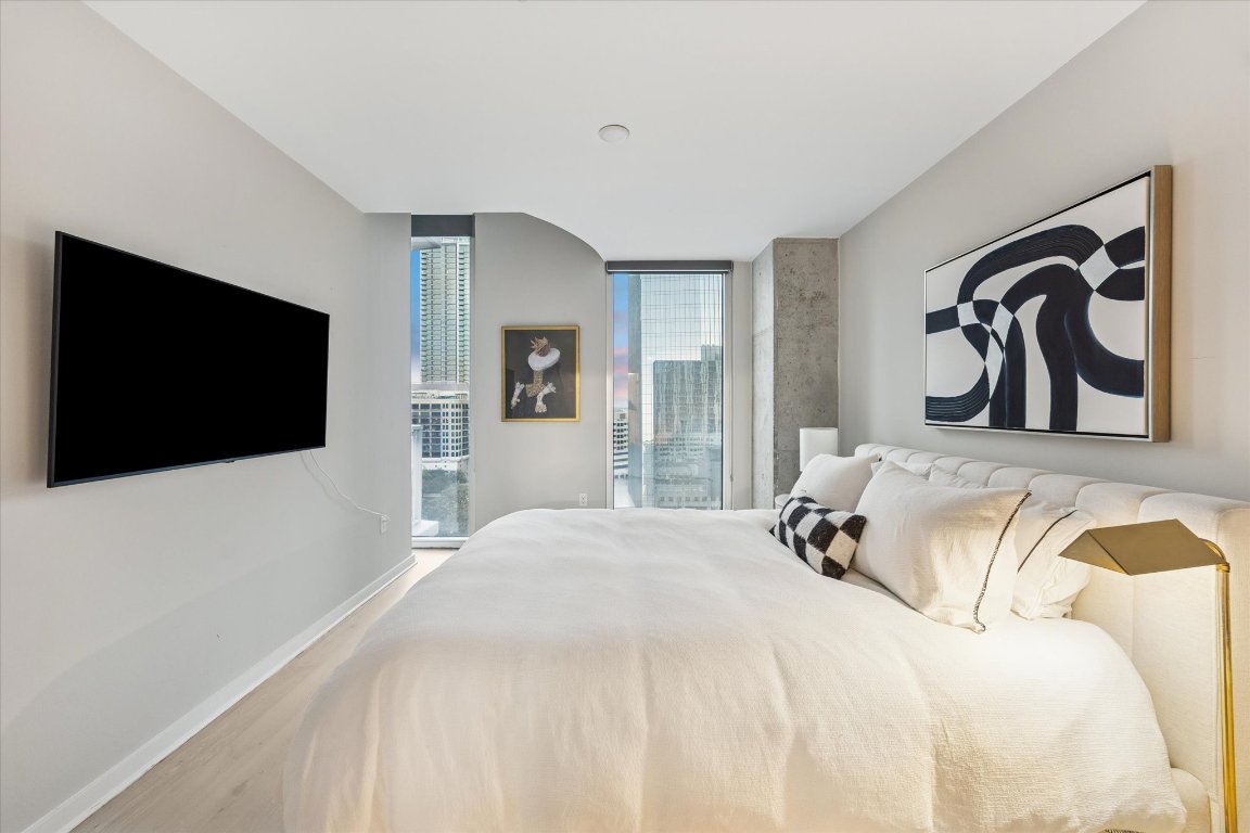 360 Nueces Street, Unit 1417 Austin, TX 78701 - Photo 20 of 40 a bedroom with a bed and a flat screen tv