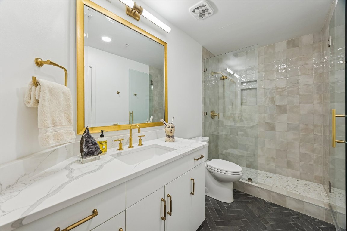 360 Nueces Street, Unit 1417 Austin, TX 78701 - Photo 27 of 40 a bathroom with a double vanity sink toilet and shower