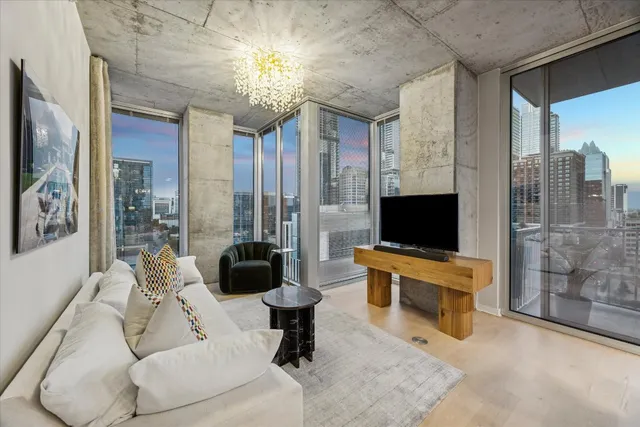 a living room with furniture a flat screen tv and a large window