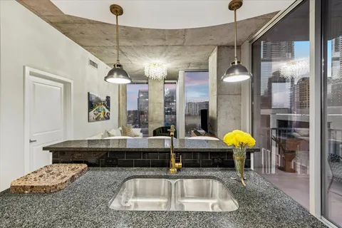 a kitchen with stainless steel appliances granite countertop a sink a stove and a wooden cabinets