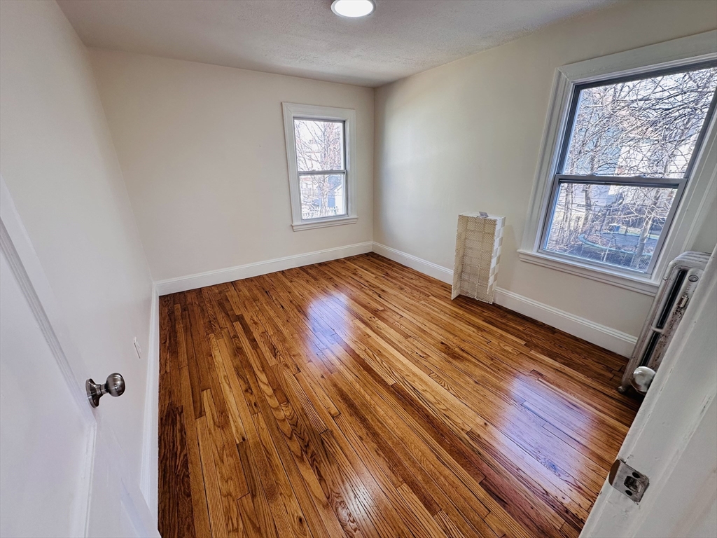 35-37 Suffolk Street Springfield, MA 01109 - Photo 14 of 17 a view of an empty room with a window and wooden floor