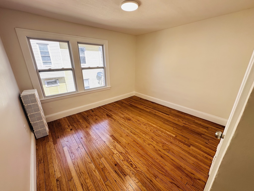 35-37 Suffolk Street Springfield, MA 01109 - Photo 15 of 17 a view of an empty room with wooden floor and a window