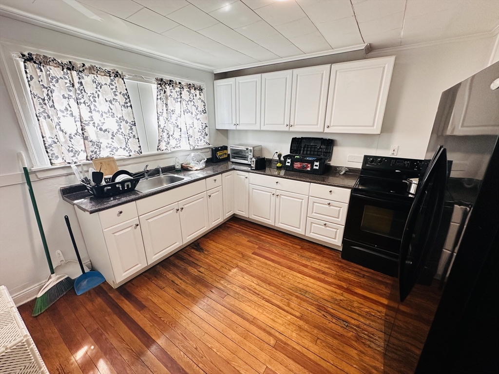 35-37 Suffolk Street Springfield, MA 01109 - Photo 5 of 17 a kitchen with granite countertop a sink cabinets and wooden floor