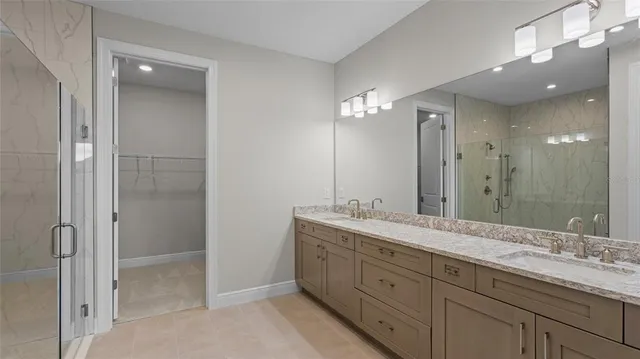 a spacious bathroom with a granite countertop sink a mirror and a shower