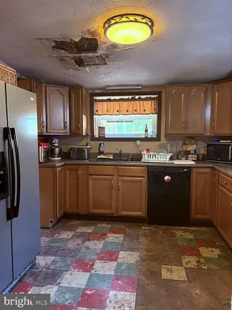 a kitchen with stainless steel appliances granite countertop a stove a sink dishwasher and a refrigerator