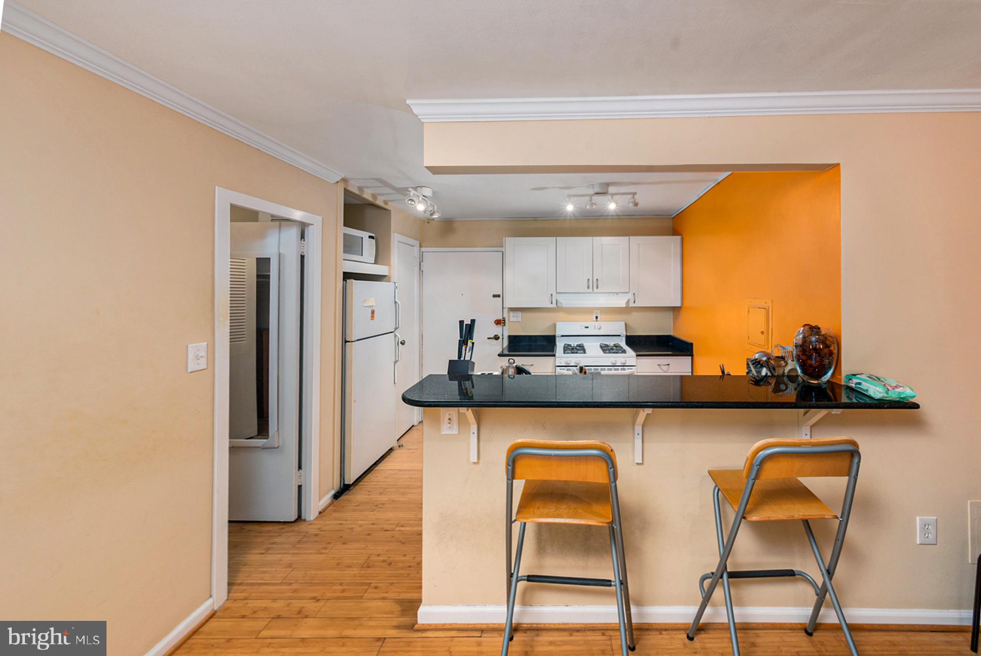 2030 F Street Northwest, Unit 209 Washington, DC 20006 - Photo 4 of 5 a kitchen with stainless steel appliances granite countertop a sink and a refrigerator