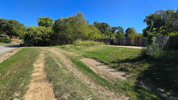 a yard with a house in the background