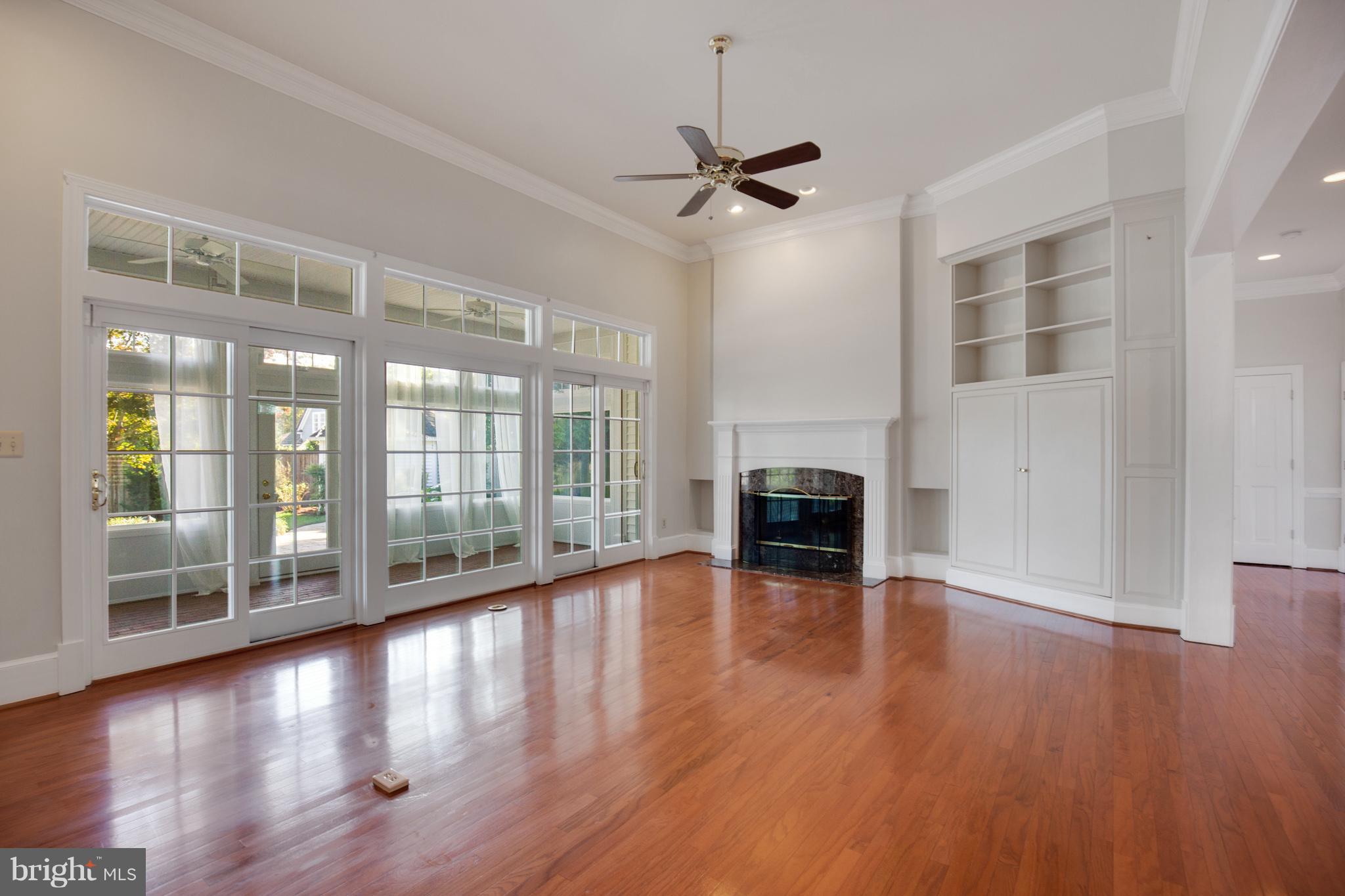 14270 Solomons Island Road South Solomons, MD 20688 - Photo 4 of 30 a view of an empty room with wooden floor fireplace and a window