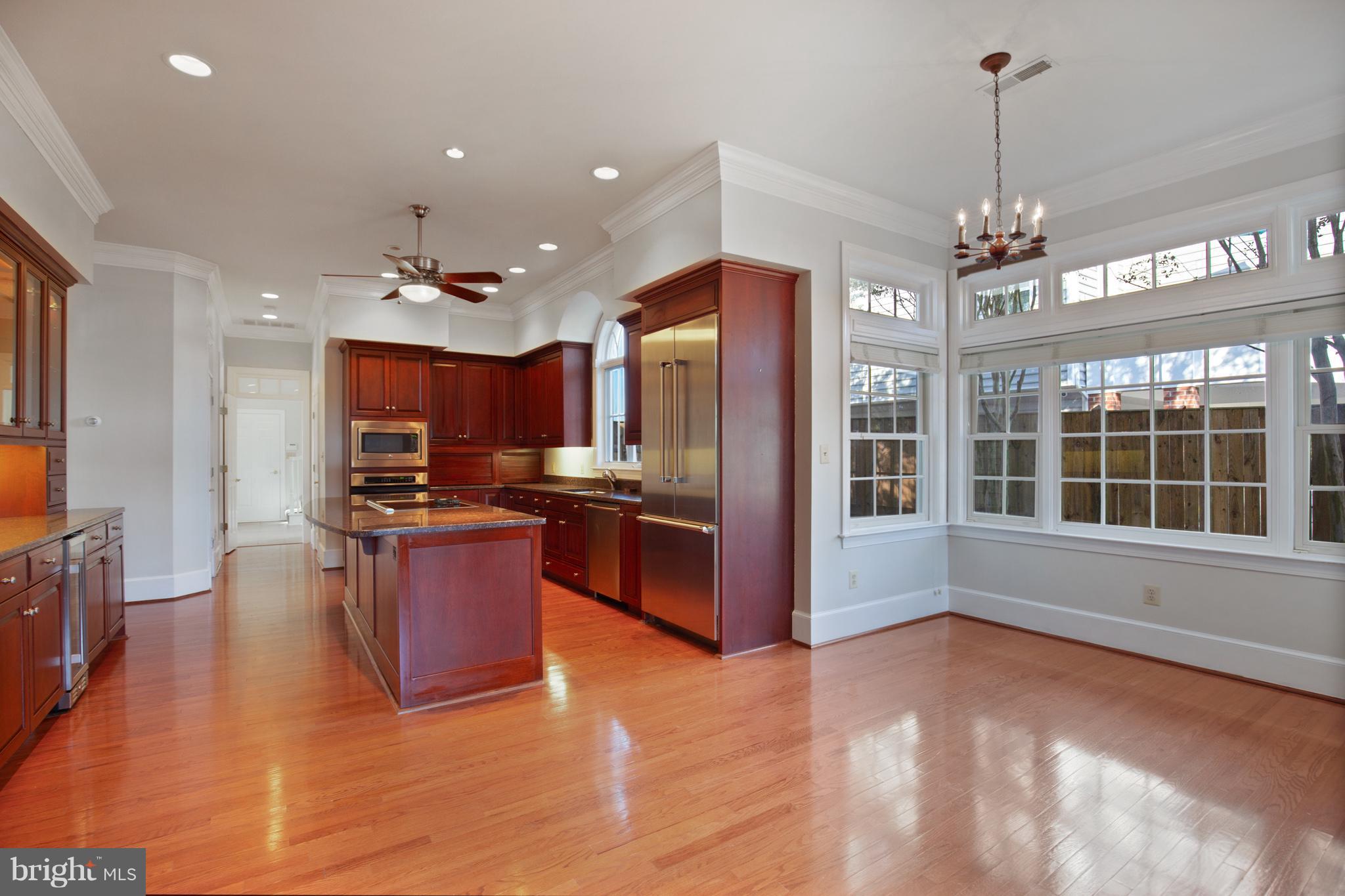14270 Solomons Island Road South Solomons, MD 20688 - Photo 7 of 30 a large kitchen with stainless steel appliances granite countertop a refrigerator a oven a dining table and chairs with wooden floor