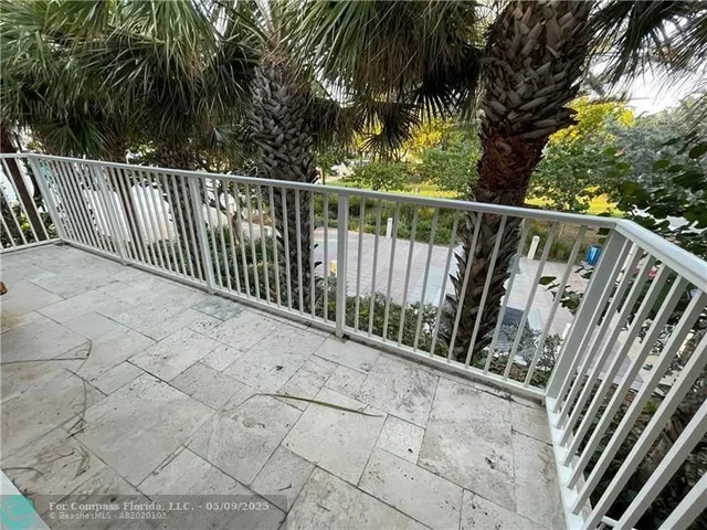 a view of balcony with wooden floor and fence