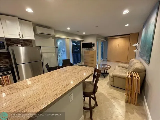 a kitchen with stainless steel appliances refrigerator dining table and chairs