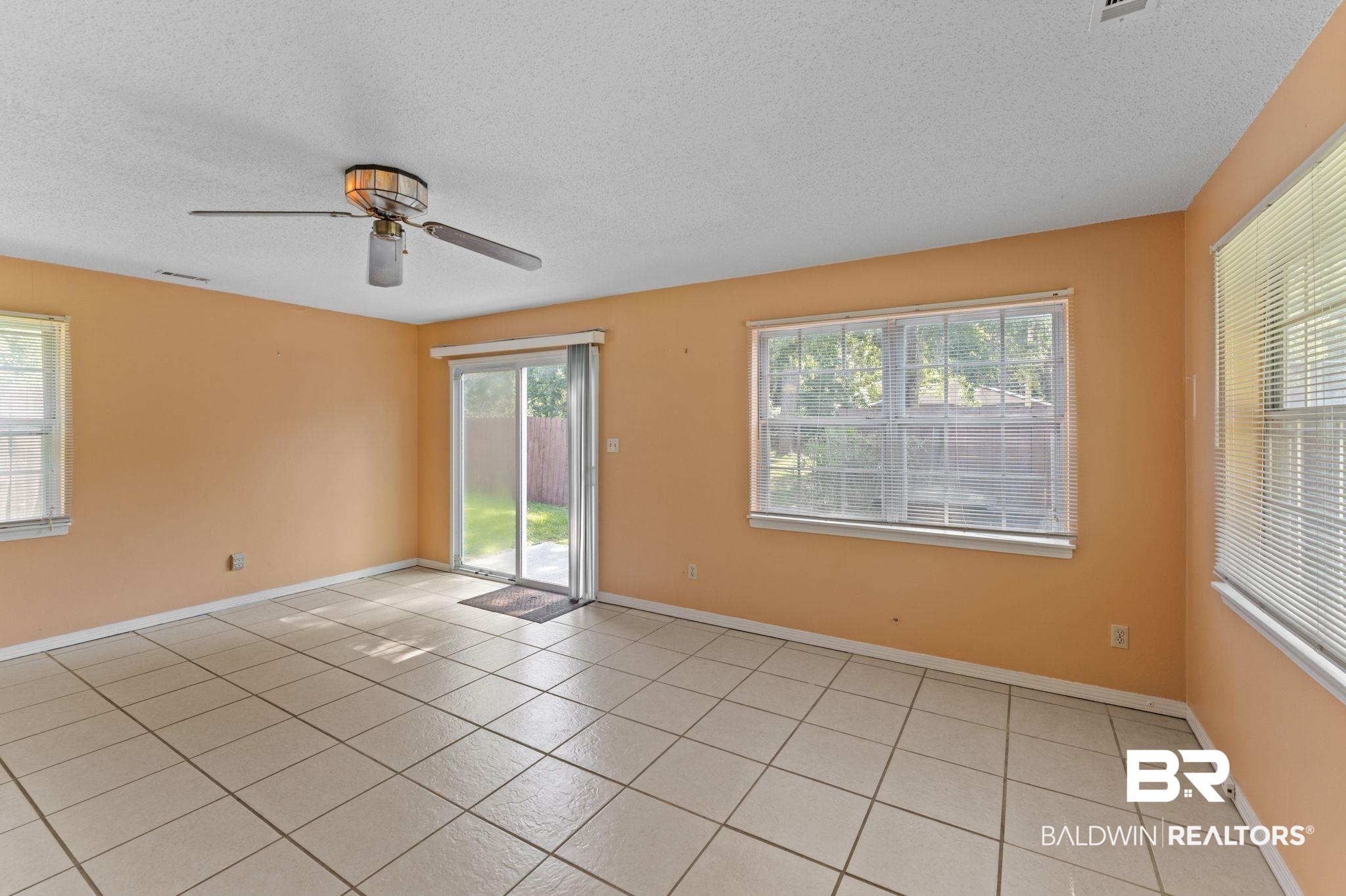14095 Riverside Drive Foley, AL 36535 - Photo 6 of 30 Empty room with plenty of natural light, a textured ceiling, light tile patterned floors, and ceiling fan