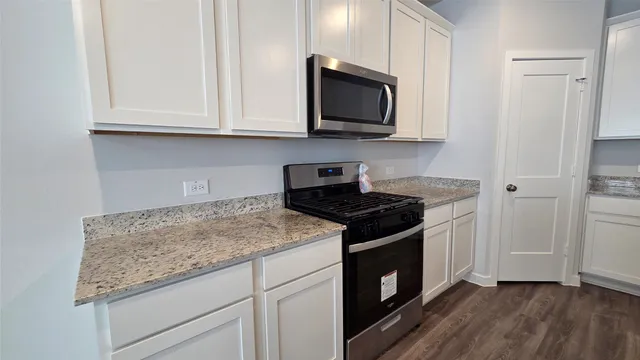 a kitchen with granite countertop cabinets and steel stainless steel appliances