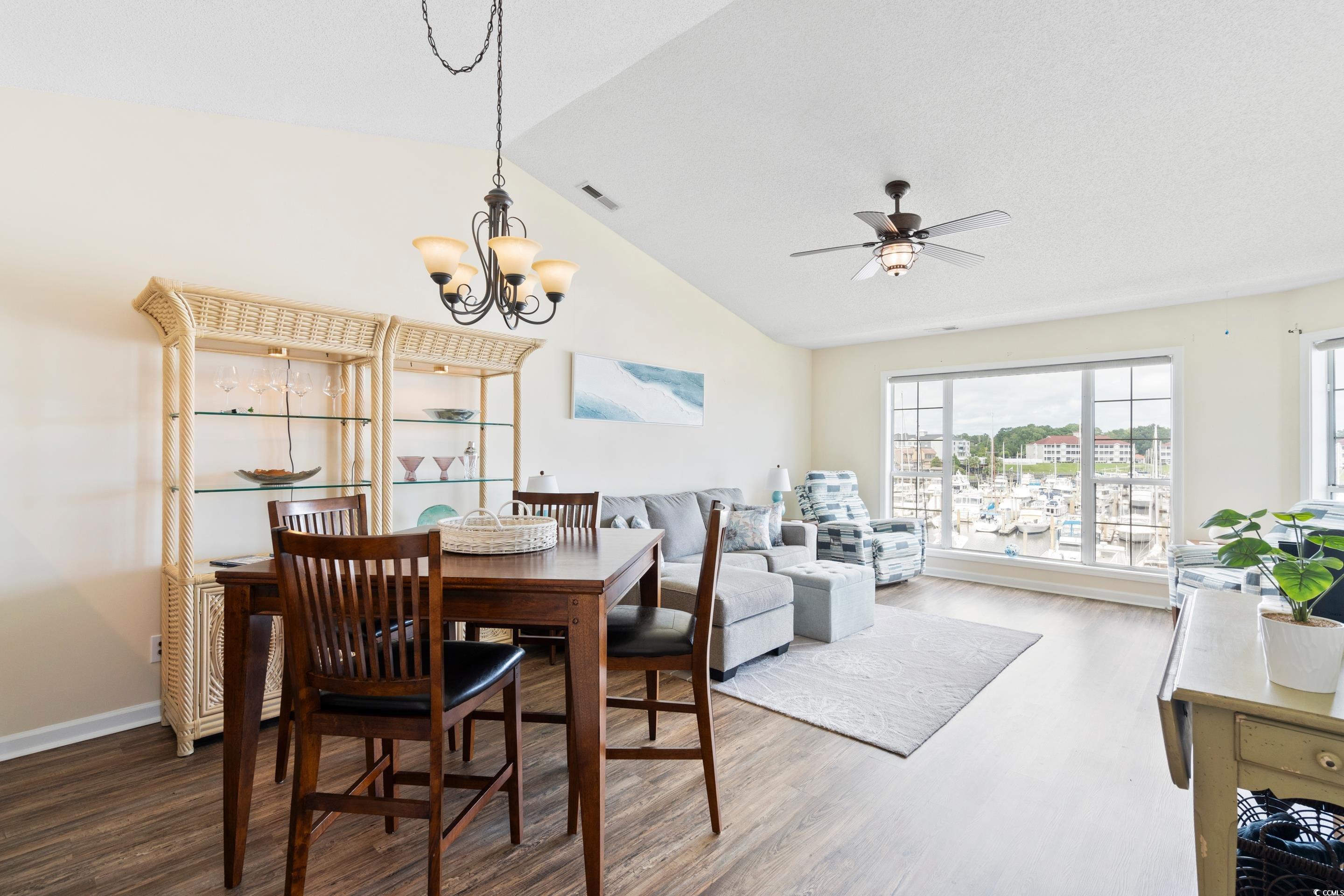 4629 Lightkeepers Way, Unit 6L Little River, SC 29566 - Photo 9 of 36 Dining room with wood finished floors, a chandelier, ceiling fan, and high vaulted ceiling