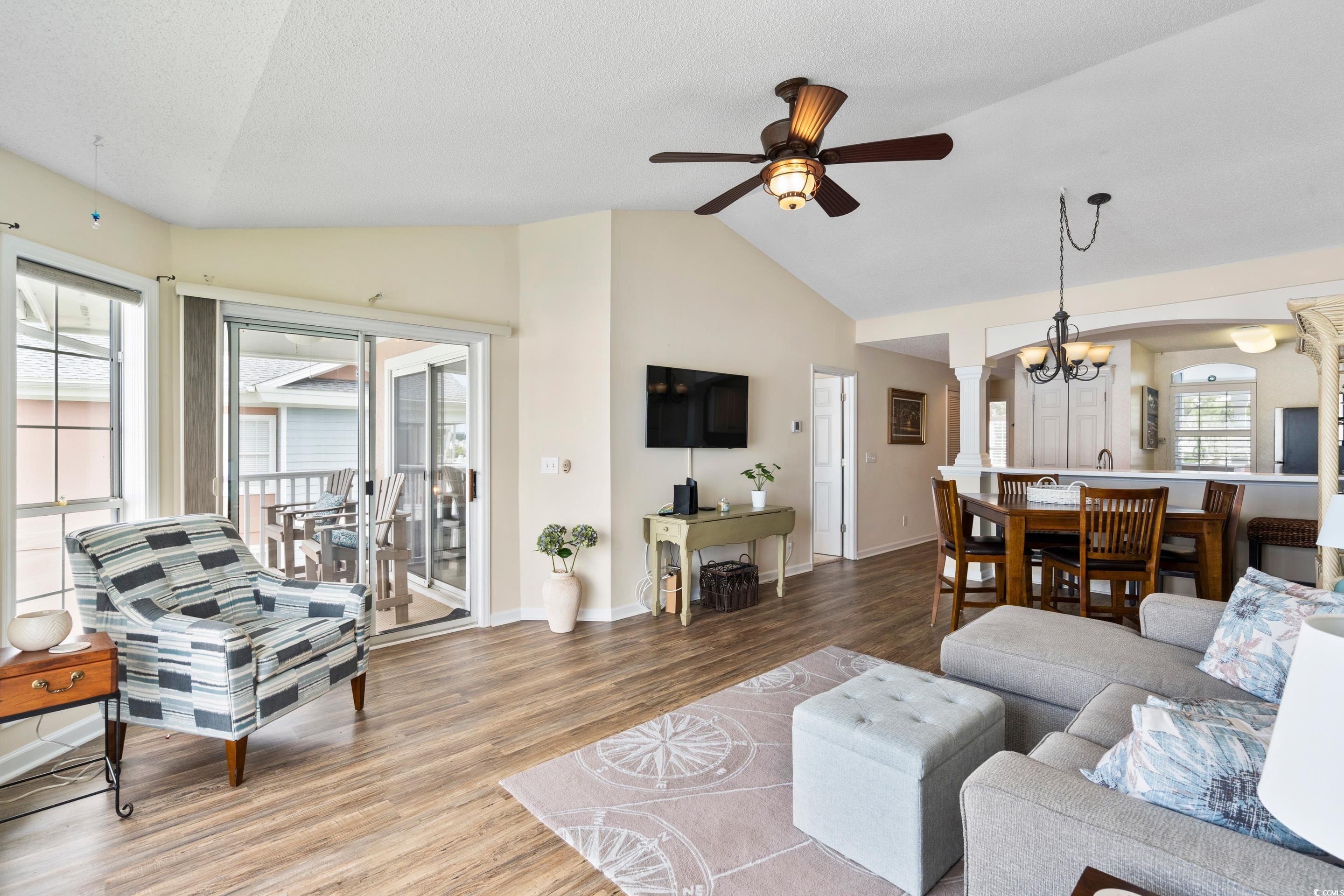 4629 Lightkeepers Way, Unit 6L Little River, SC 29566 - Photo 11 of 36 Living room with wood finished floors, vaulted ceiling, a ceiling fan, a chandelier, and a textured ceiling
