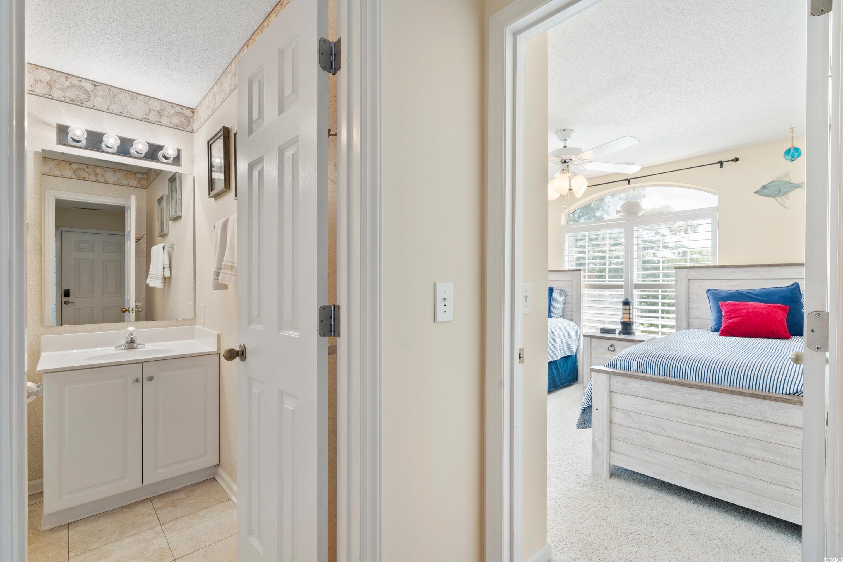 4629 Lightkeepers Way, Unit 6L Little River, SC 29566 - Photo 16 of 36 Ensuite bathroom with a textured ceiling, vanity, light tile patterned floors, and ceiling fan