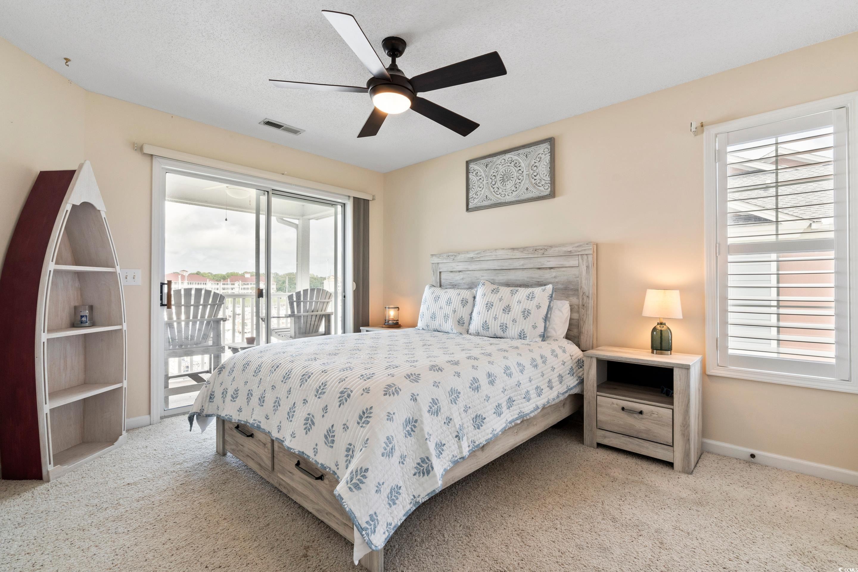4629 Lightkeepers Way, Unit 6L Little River, SC 29566 - Photo 17 of 36 Bedroom with light colored carpet, access to outside, a ceiling fan, and a textured ceiling