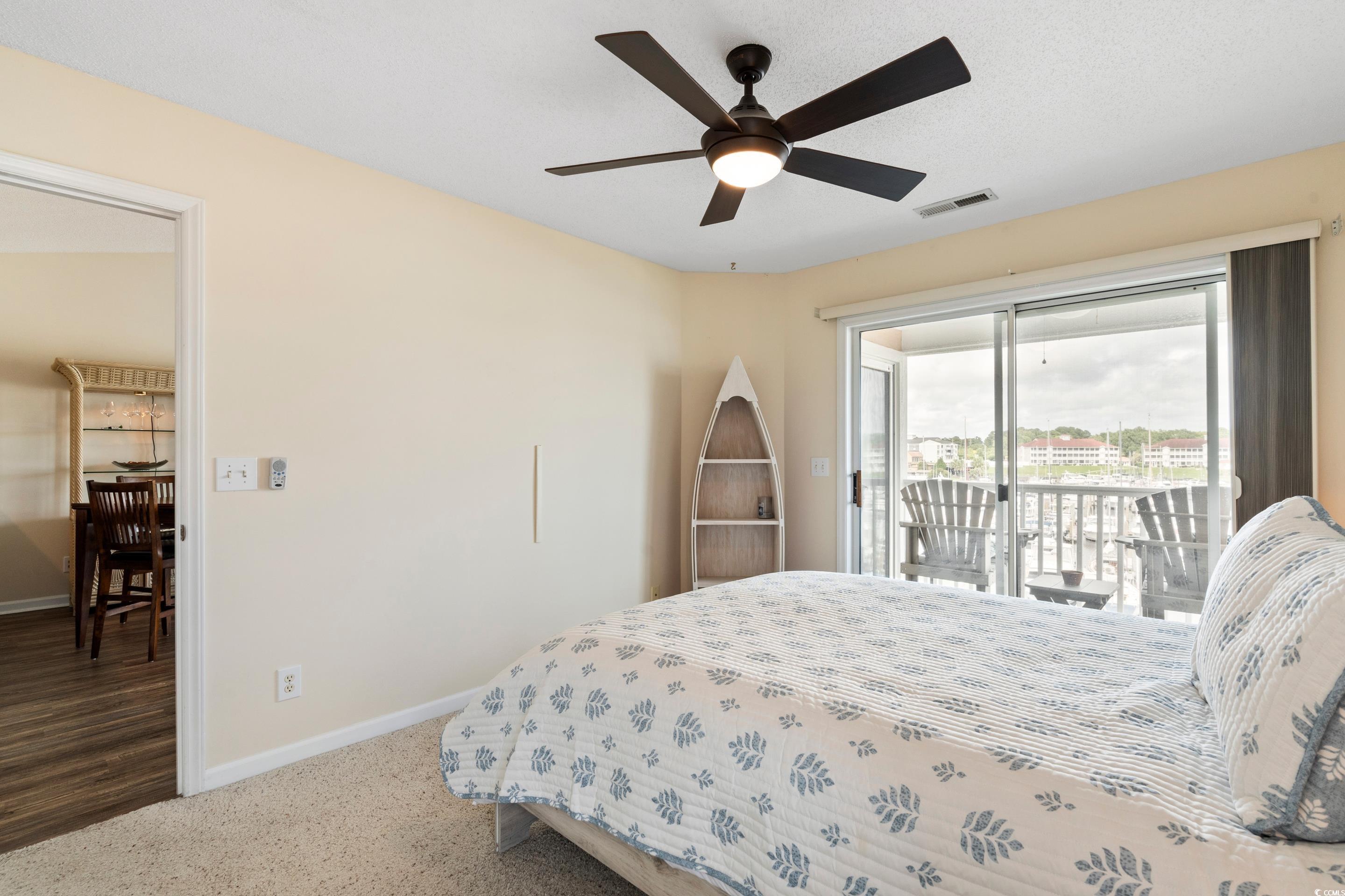 4629 Lightkeepers Way, Unit 6L Little River, SC 29566 - Photo 18 of 36 Bedroom featuring access to exterior, a ceiling fan, and carpet flooring
