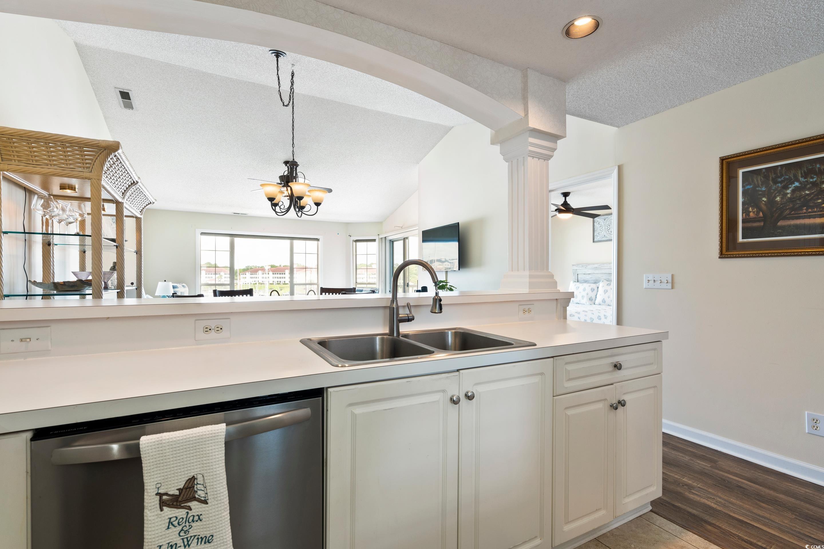 4629 Lightkeepers Way, Unit 6L Little River, SC 29566 - Photo 7 of 36 Kitchen with dishwasher, light countertops, lofted ceiling, white cabinets, and dark wood-style floors