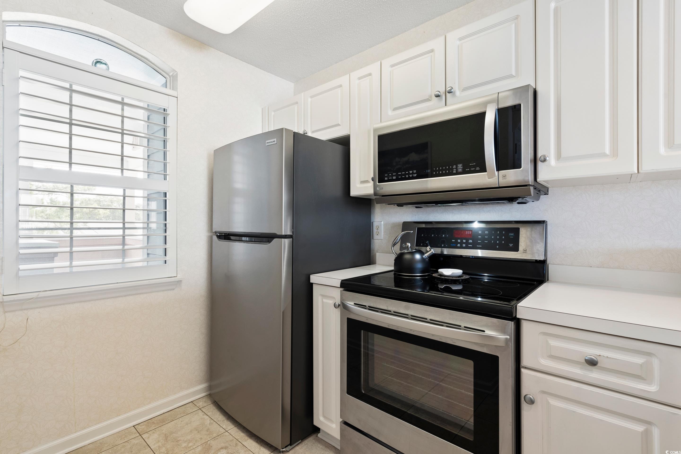 4629 Lightkeepers Way, Unit 6L Little River, SC 29566 - Photo 8 of 36 Kitchen featuring appliances with stainless steel finishes, healthy amount of natural light, light countertops, and white cabinets
