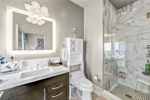a bathroom with a sink a toilet a mirror and shower
