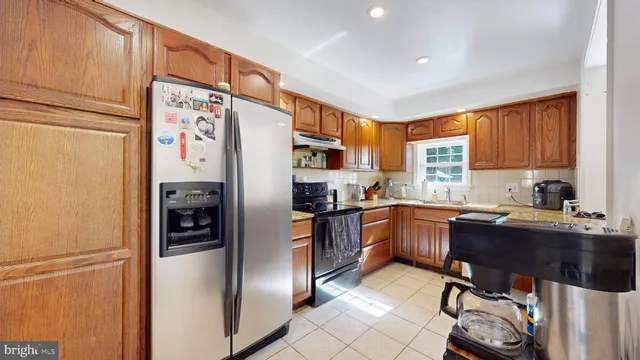 a kitchen with stainless steel appliances white cabinets and a refrigerator