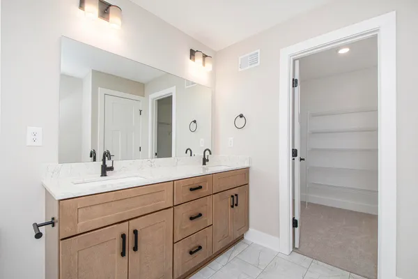 a bathroom with a double vanity sink and mirror