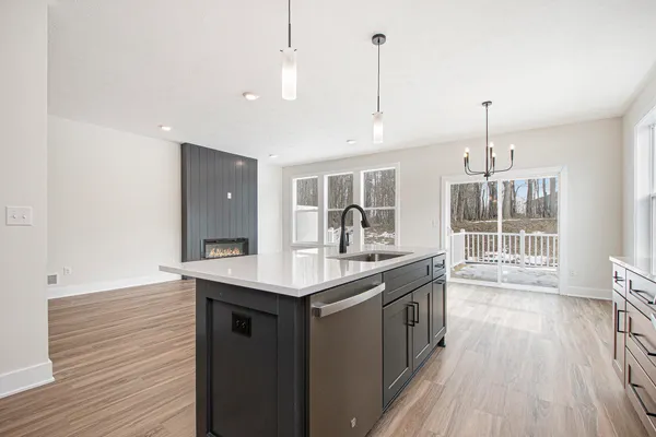 a kitchen with a sink and wooden floor
