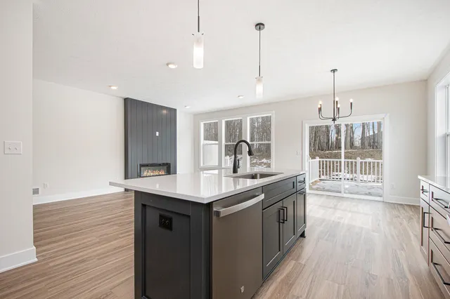 a kitchen with a sink and wooden floor