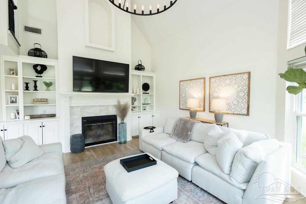 3059 Cobblestone Drive Pace, FL 32571 - Photo 12 of 45 a living room with furniture a fireplace and a flat screen tv