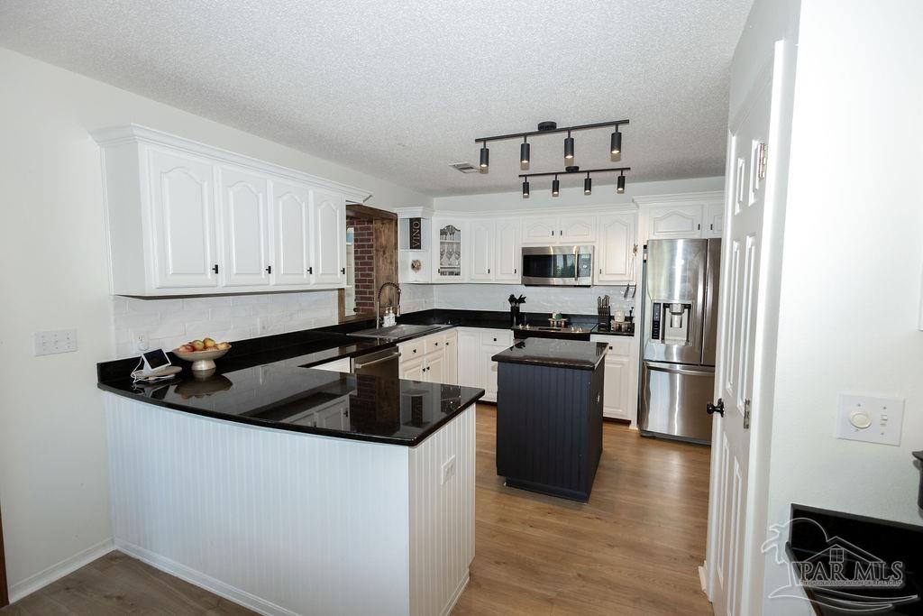 3059 Cobblestone Drive Pace, FL 32571 - Photo 18 of 45 a kitchen with a refrigerator and a stove top oven