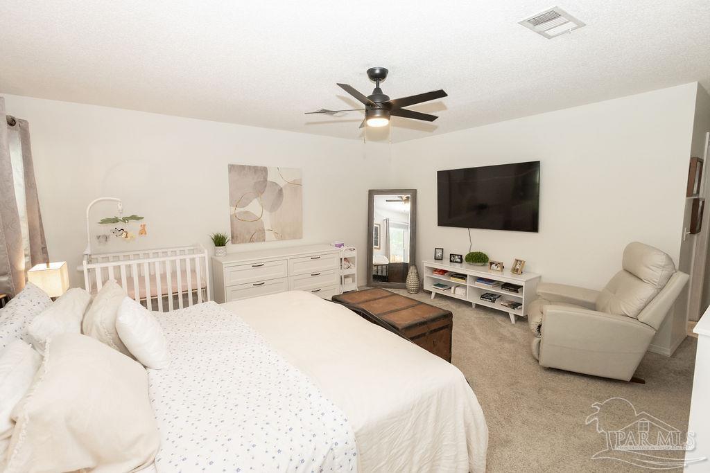 3059 Cobblestone Drive Pace, FL 32571 - Photo 23 of 45 a bedroom with a bed and a flat screen tv