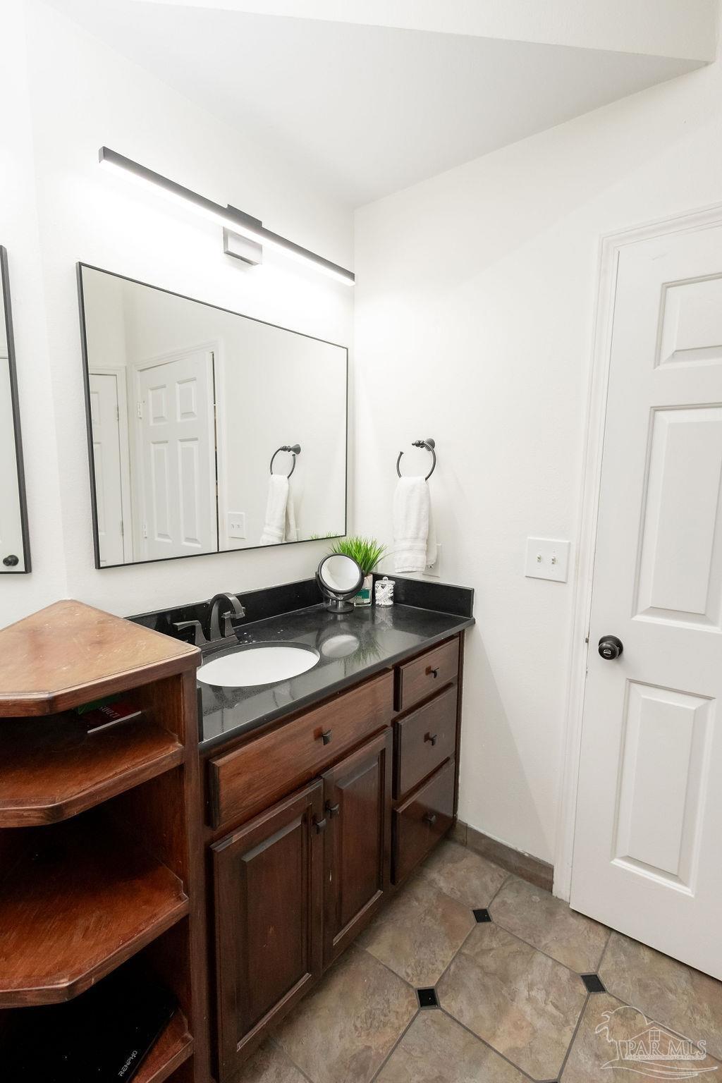 3059 Cobblestone Drive Pace, FL 32571 - Photo 26 of 45 a bathroom with a sink and a mirror