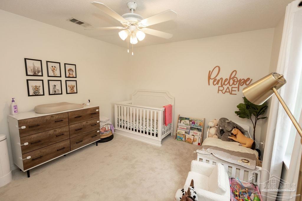 3059 Cobblestone Drive Pace, FL 32571 - Photo 33 of 45 a bedroom with furniture and a chandelier fan