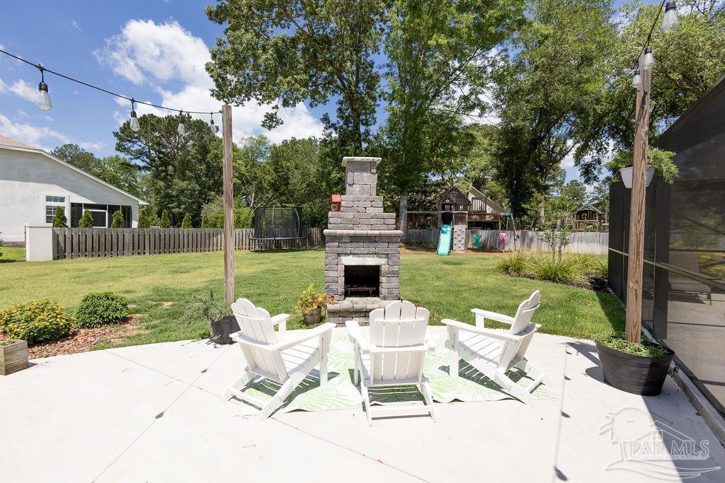 3059 Cobblestone Drive Pace, FL 32571 - Photo 4 of 45 a view of a chair and tables in the yard in front of house