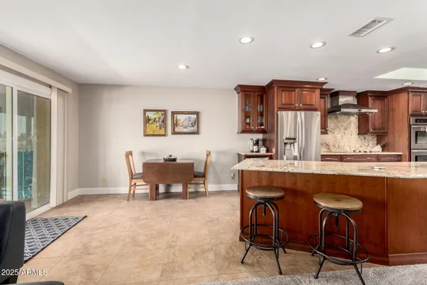 a large kitchen with stainless steel appliances granite countertop a sink stove and cabinets