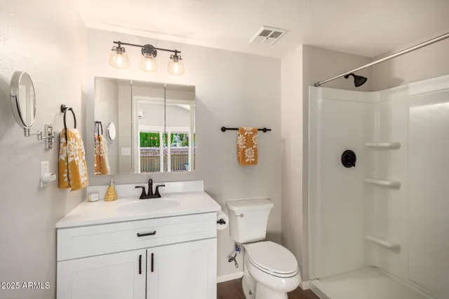 a bathroom with a granite countertop sink toilet and shower