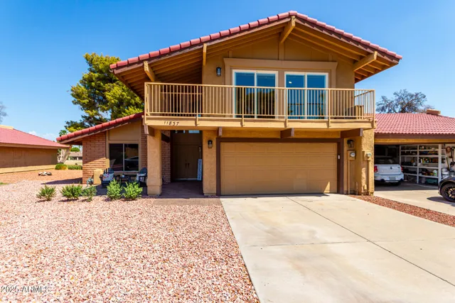 a view of a patio with table and chairs and wooden fence