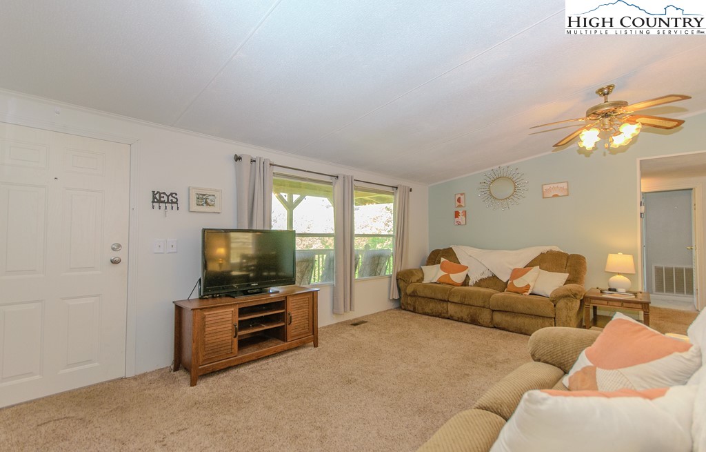 295 Roy E Brown Road Vilas, NC 28692 - Photo 15 of 43 a living room with furniture a flat screen tv and a chandelier
