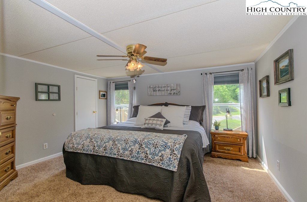 295 Roy E Brown Road Vilas, NC 28692 - Photo 20 of 43 a bedroom with a bed and a chandelier