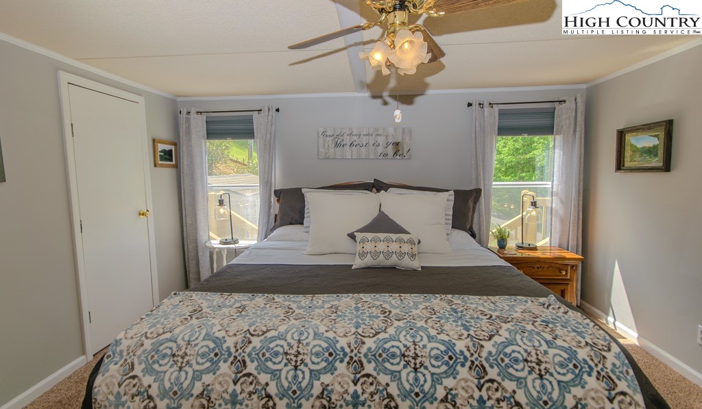 295 Roy E Brown Road Vilas, NC 28692 - Photo 21 of 43 a bedroom with a large bed and a chandelier