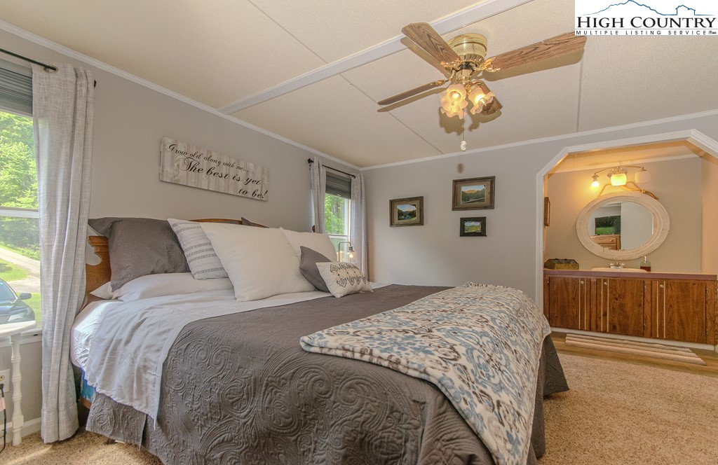295 Roy E Brown Road Vilas, NC 28692 - Photo 23 of 43 a bedroom with a bed and a chandelier