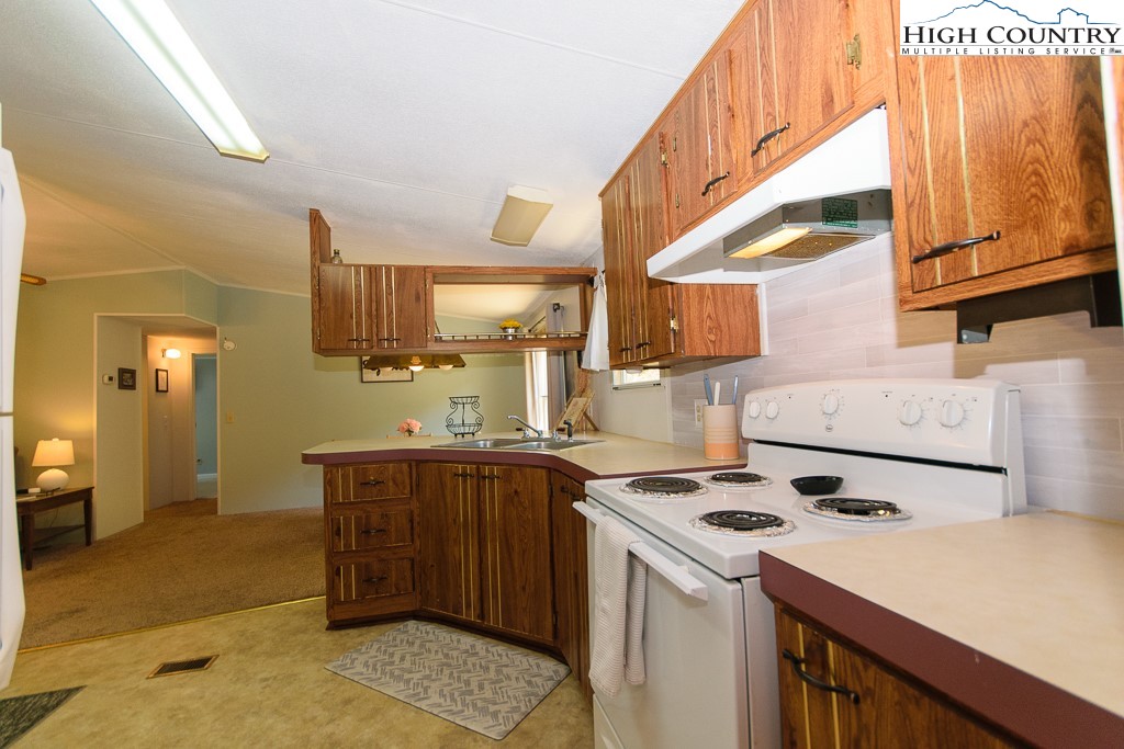 295 Roy E Brown Road Vilas, NC 28692 - Photo 30 of 43 a kitchen with a sink a stove cabinets and a dining table