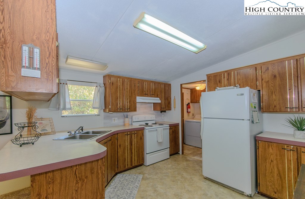 295 Roy E Brown Road Vilas, NC 28692 - Photo 32 of 43 a kitchen with a sink a refrigerator and a stove