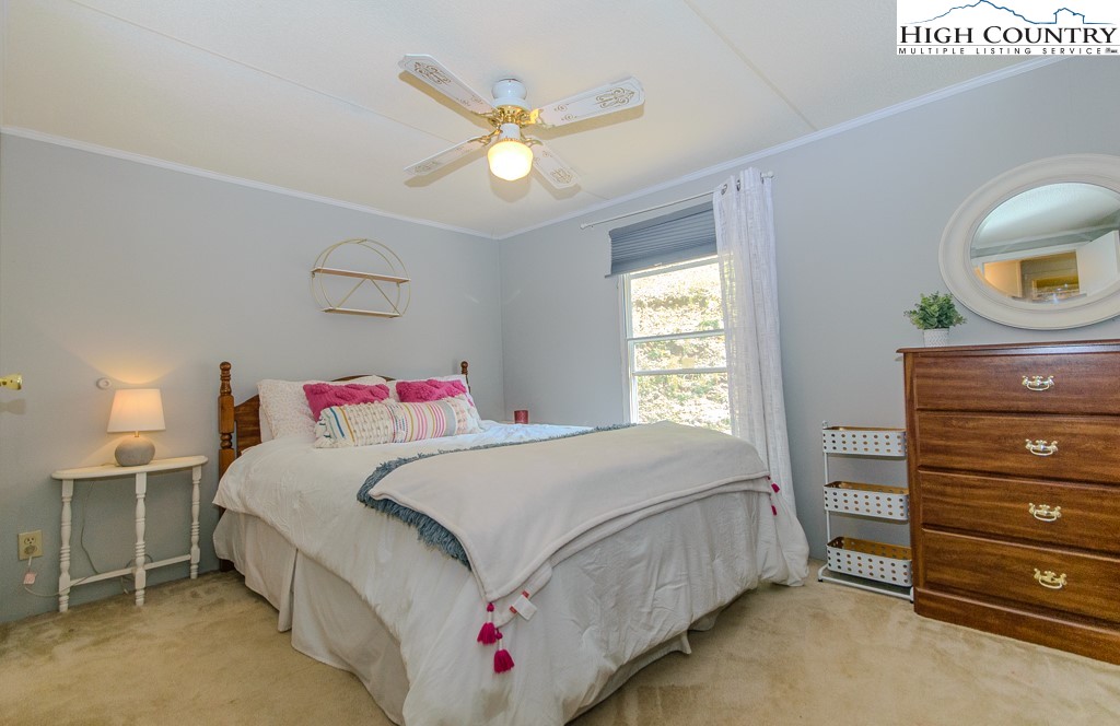 295 Roy E Brown Road Vilas, NC 28692 - Photo 39 of 43 a bedroom with a bed and a chandelier