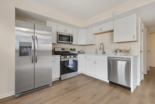 a kitchen with a refrigerator sink and cabinets