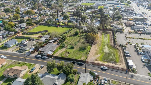 an aerial view of a residential houses with outdoor space and lake view