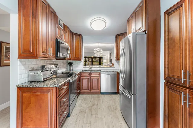 a kitchen with stainless steel appliances granite countertop a stove a sink dishwasher and a refrigerator